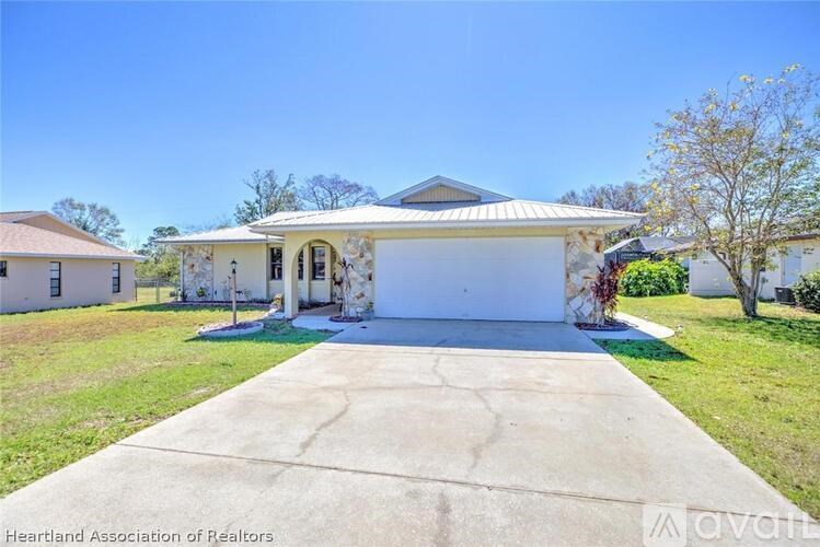 A house with a white garage door and a driveway in front.