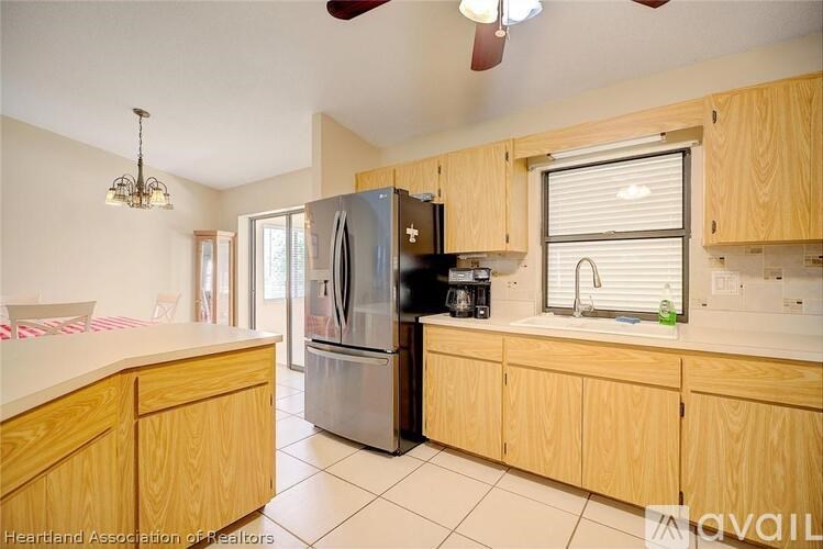 A kitchen with wooden cabinets and a black refrigerator.