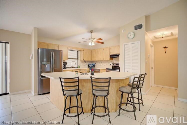 A kitchen with a bar area and four stools.
