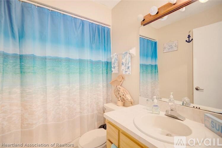 A bathroom with a beach scene shower curtain.