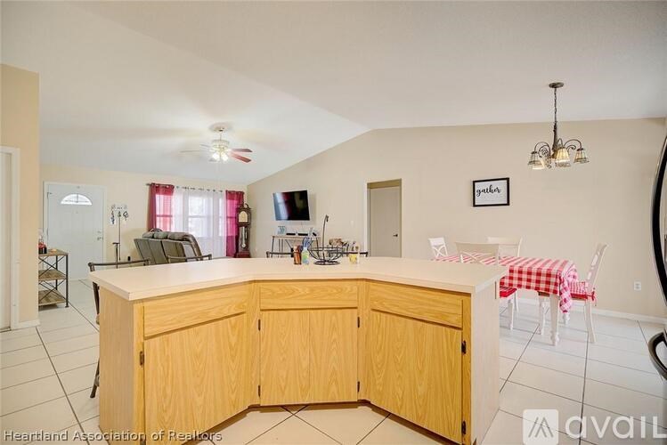A kitchen with wooden cabinets and a checkered tablecloth.