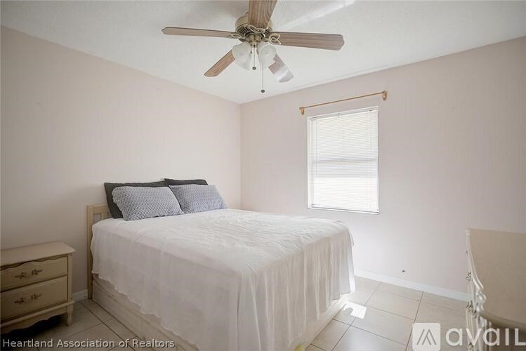A bedroom with a bed, dresser, and window.