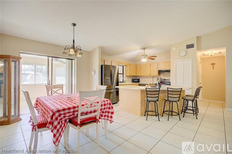 A kitchen with a table set for four with a red and white checkered tablecloth.