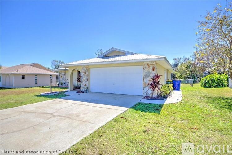 A white house with a garage and a driveway in front.