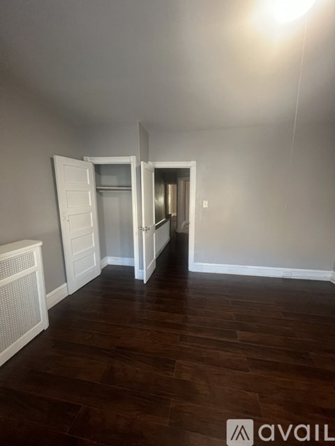 A room with a wooden floor and a white door.