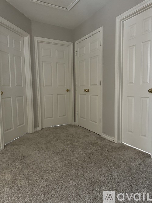A room with three white doors and a carpeted floor.