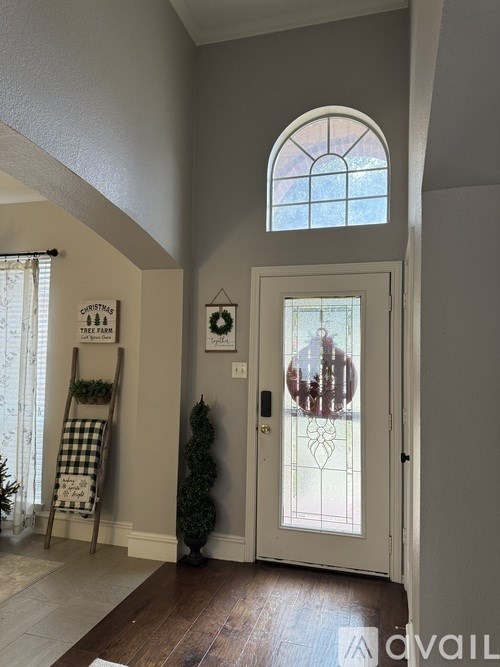 A white door with a glass window is in a room with a wooden floor.