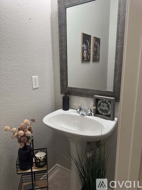 A bathroom with a white sink and a mirror.