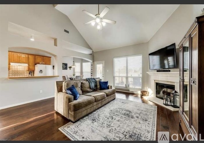 A living room with a couch, a fireplace, and a television.