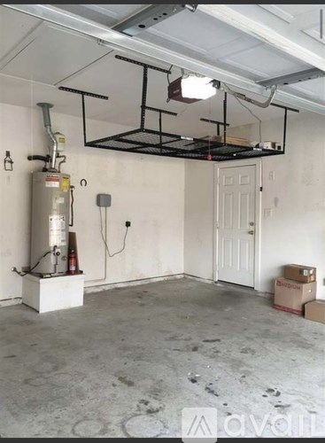 A room with a white door and a white ceiling with a black pipe and a black frame hanging from it.