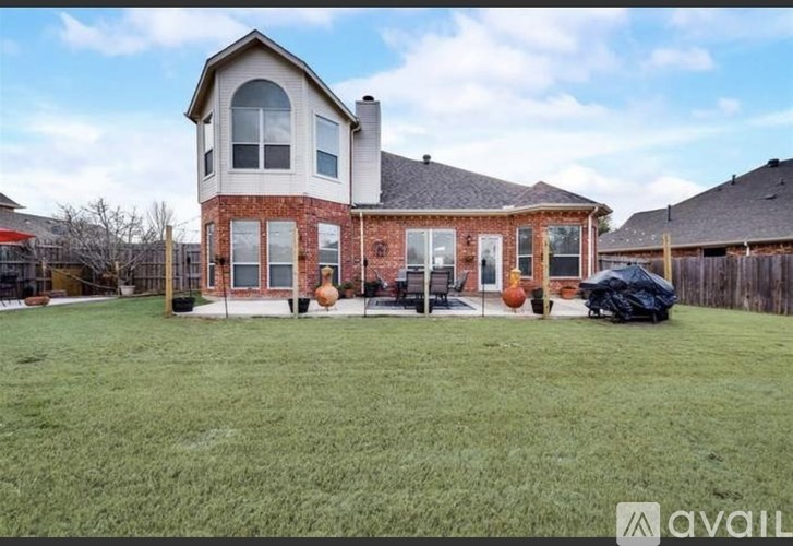 A house with a large lawn and a black car parked in front.