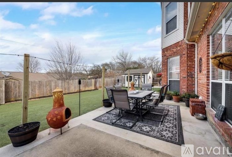 A patio with a table and chairs is set up outside a house.