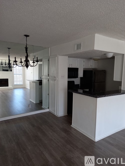 A kitchen with a white island and a chandelier.