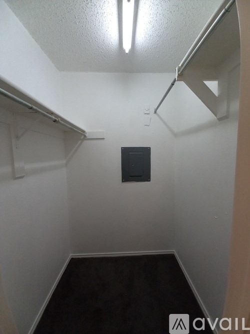 A small, empty room with a black door in the middle.