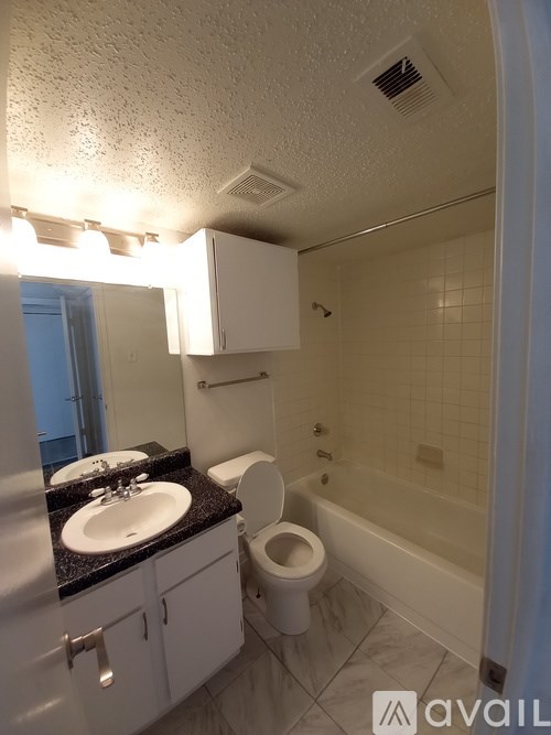 A bathroom with a sink, toilet, and bathtub.