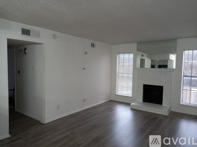 A spacious living room with a fireplace and large windows.