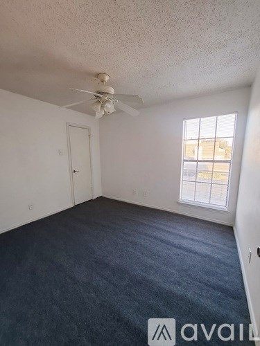 A room with a ceiling fan and a window.