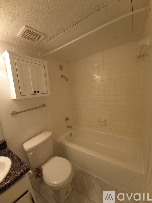 A white toilet sits next to a bathtub in a bathroom.