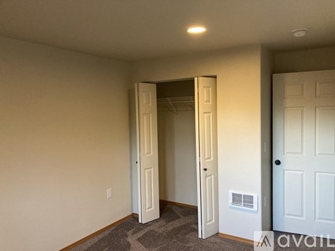 A room with a carpeted floor and a white door.