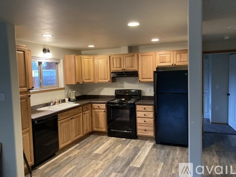 A kitchen with wooden cabinets and black appliances.