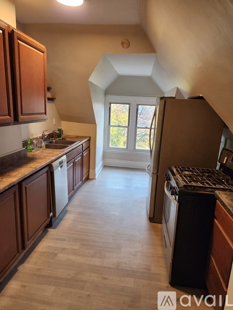 A kitchen with wooden cabinets and a black dishwasher.