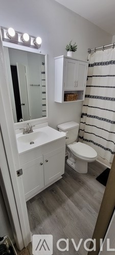 A bathroom with a white sink, toilet, and striped shower curtain.