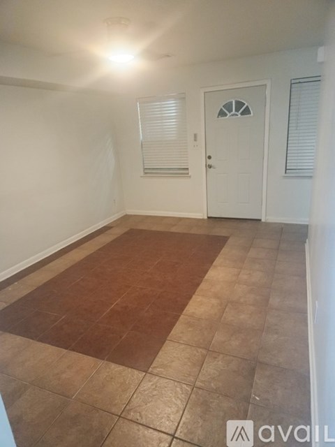 A room with a brown tile floor and a white door.
