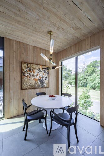 A dining room with a round table and chairs.