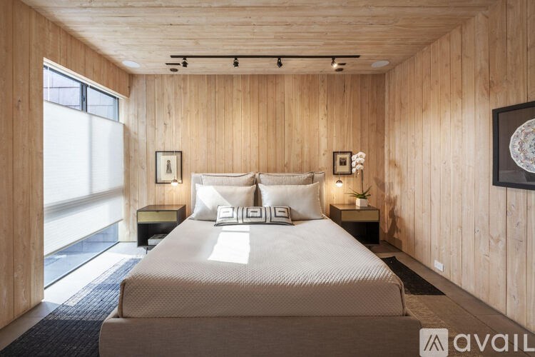 A bedroom with a large bed and wooden walls.