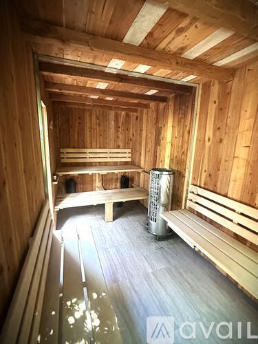A sauna with wooden benches and a heater in the middle.