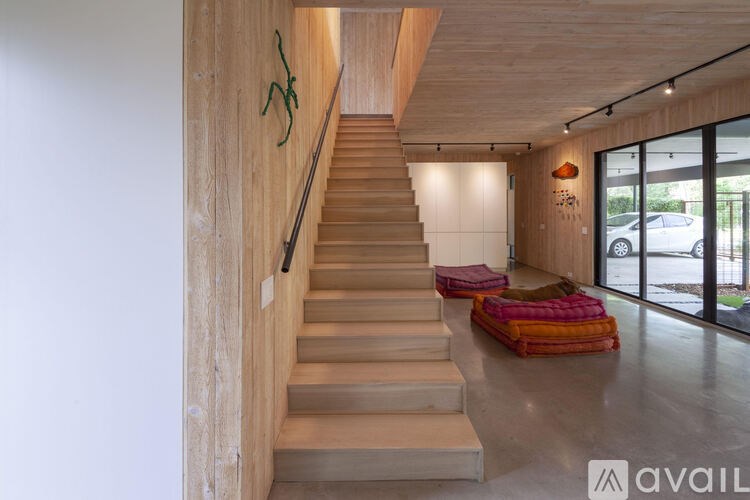A wooden staircase with a green plant on the wall.