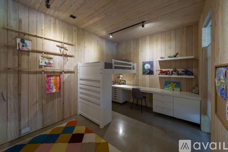A room with wooden walls and a white desk with a chair.