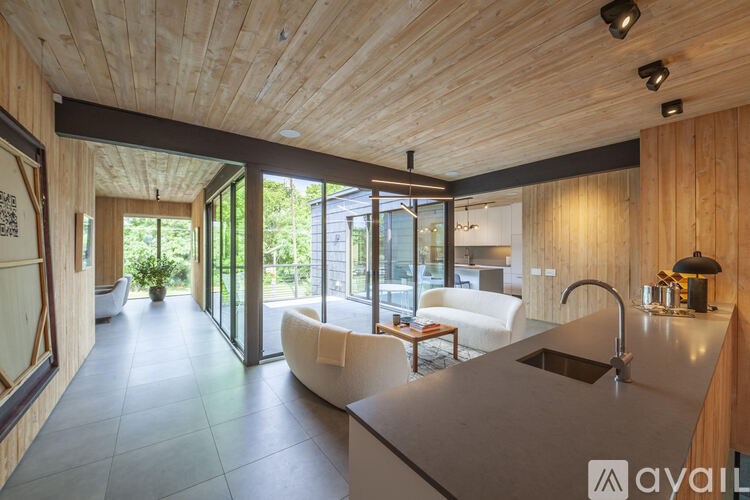 A modern kitchen with wooden ceiling and a large island.