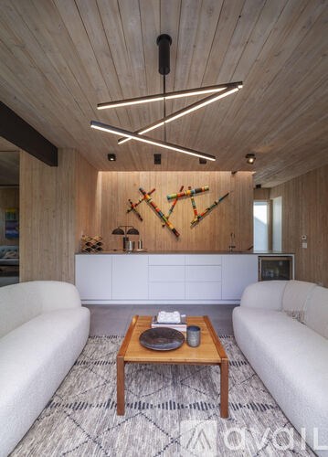 A modern living room with a wooden ceiling and a white sofa.