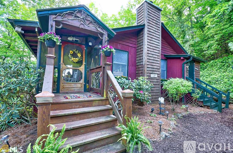 A house with a red exterior and a wooden staircase leading to a porch.