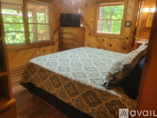 A bedroom with a bed, a dresser, and a window.