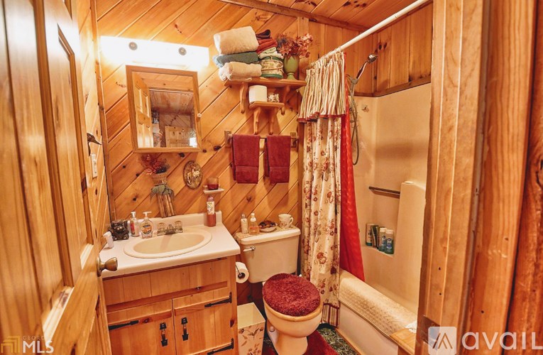 A wooden bathroom with a toilet, sink, and shower.