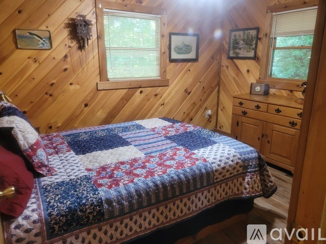 A bedroom with a bed, dresser, and window.