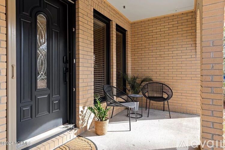 A black door with a glass window is on a brick wall.