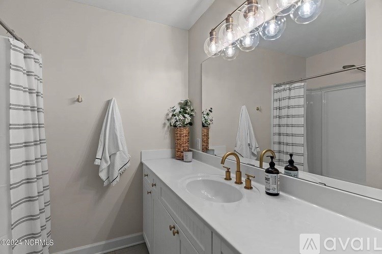 A bathroom with a white countertop and a mirror above it.
