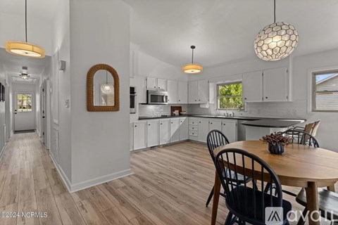 A modern kitchen with a wooden table and chairs.
