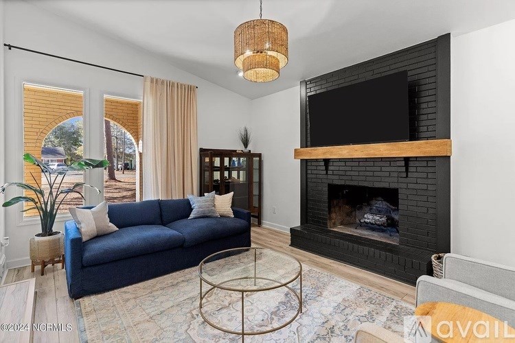 A living room with a fireplace and a blue couch.