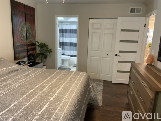 A bedroom with a large bed and a dresser.