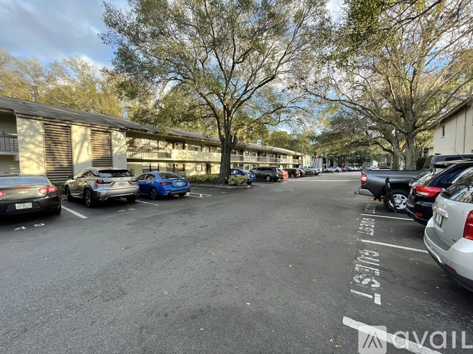 A parking lot with cars and a building in the background.