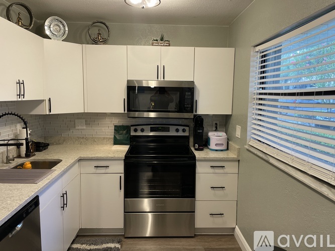 A kitchen with white cabinets and a black stove top oven.