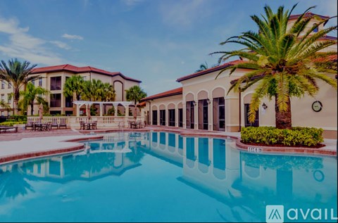 A large pool in front of a building with a palm tree.