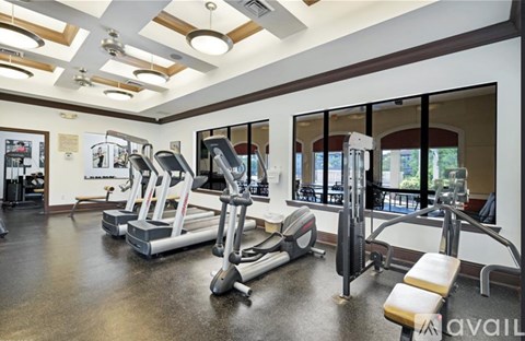 A gym with treadmills, elliptical machines, and other exercise equipment.