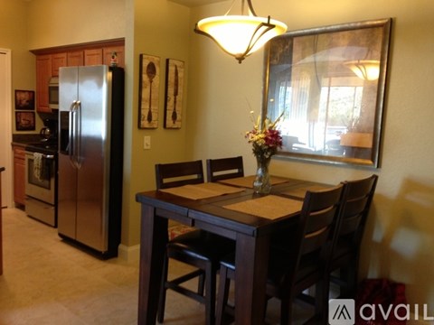 A kitchen with a table and chairs and a fridge.
