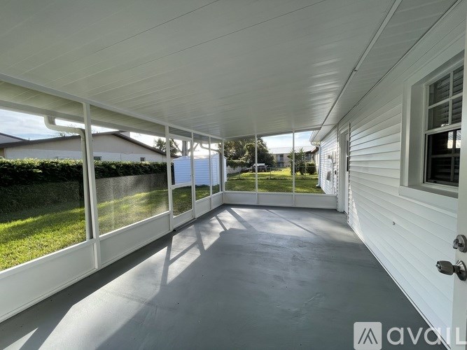 A white covered patio with a white door and a white wall.