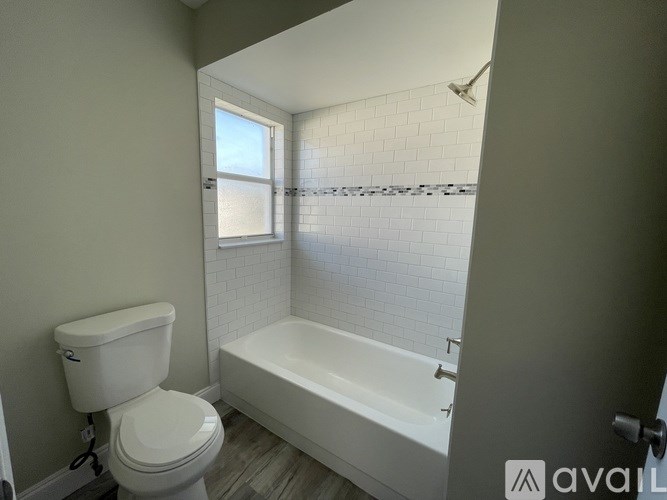 A white toilet sits next to a bathtub in a bathroom.